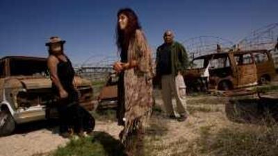 Natalie Zakai, centre, and Weisman Zakai, left, stand near the charred remains of their vehicles with Ahmed Tarabin in Nevatim, a community of 650 Jews a few kilometres from the city of Beersheva.