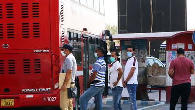 People wearing protective masks wait to board a bus at a station in Kuwait City, as businesses such as barbershops, beauty salons, gyms and spas, reopen after a 5-month shutdown due to the spread of the novel coronavirus (COVID-19). AFP