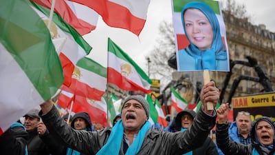 People wave former Iranian flags and a picture of Maryam Rajavi, leader of the People's Mujahedin of Iran. AFP