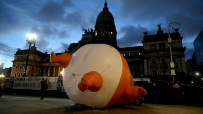 G20 summit protesters deflate a giant doll depicting US President Trump wearing a nappy in front of Argentina's congress. AP Photo