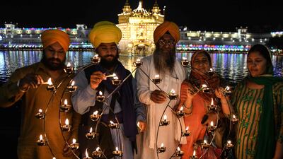 Sikh devotees light candles on the occasion of the Baisakhi festival at the Golden Temple, Amritsar. AFP