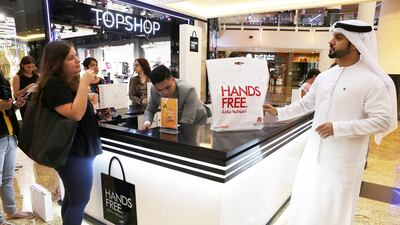 Hussain Moosa , director of Mall of the Emirates, informs a customer about the mall’s hands free shopping service. Pawan Singh / The National