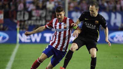 Barcelona midfielder Andres Iniesta, right, vies with Atletico Madrid midfielder and captain Gabi during their Uefa Champions League quarter-final second leg at the Vicente Calderon stadium in Madrid on April 9, 2014. Curto de la Torre / AFP