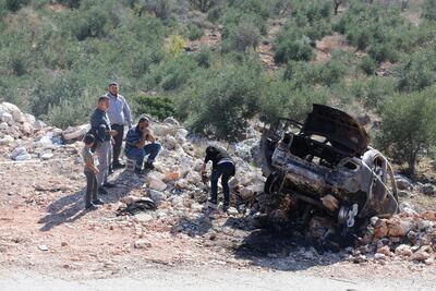 Palestinians inspect a car at Qarawa village in the occupied West Bank after extremist Israeli settlers burnt it. EPA