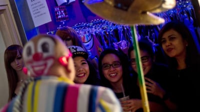A clown entertains passersby as a group of the entertainers parade during the Clown Festival.