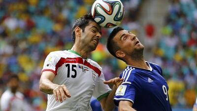 Iran's Pejman Montazeri, left, jumps for the ball with Bosnia's Vedad Ibisevic during their 2014 World Cup Group F match on Wednesday. Ivan Alvarado / Reuters