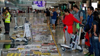 Travellers look at placards and posters placed by protesters at the airport in Hong Kong. AP Photo