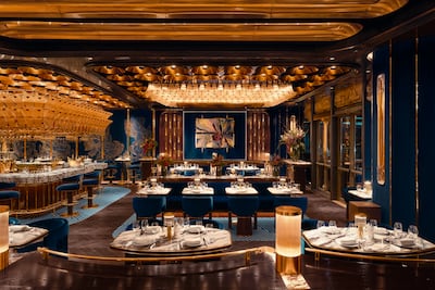 The dining room complete with deep blue velvet seating, brass accents and an abundance of flowers. Photos: Isabel Mayfair Abu Dhabi