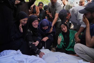 Walaa Al Kilani, right, mourns with other relatives over the bodies of her mother and brother, who were killed when an Israeli military strike hit a school sheltering displaced residents. AP