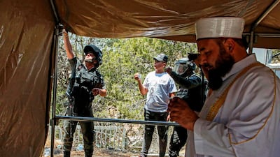 A Palestinian imam leads prayers inside a protest tent erected during a demonstration against the demolishing of buildings in the Palestinian village of Beit Sahur in the occupied West Bank, as Israeli security forces outside attempt to dismantle the tent. AFP
