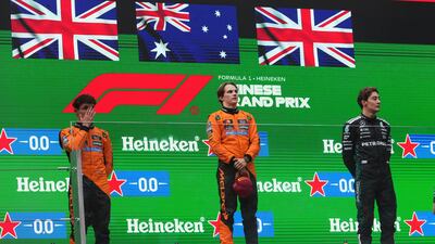 McLaren driver Oscar Piastri, centre, celebrates on the podium with McLaren driver Lando Norris, left, and Mercedes driver George Russell. AP