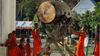 A monk beats a giant drum at a pagoda near Phnom Penh after three Khmer Rouge torture sites were added to Unesco’s World Heritage List. AP
