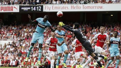 West Ham United's Senegalese midfielder Cheikhou Kouyate, left, scores the opening goal of their Premier League match against Arsenal at the Emirates Stadium in London on August 9, 2015. AFP PHOTO / ADRIAN DENNIS