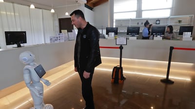 Mihail Slanina, a guest from Moldavia, asks robot concierge Robby Pepper for information. Luca Bruno/AP