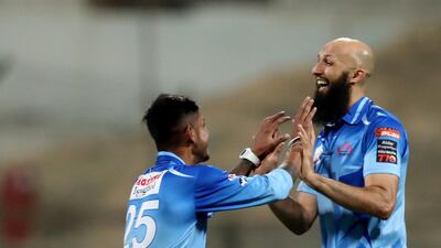 Karnataka Tuskers' Hashim Amla, right, and Sandeep Lamichhane celebrate after the run out of Bangla Tigers batsman Colin Ingram. Chris Whiteoak / The National