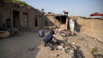 Samiullah, who says he is 14 years old, washes dishes at a coal mine in Choa Saidan Shah, Punjab. Sara Farid / Reuters