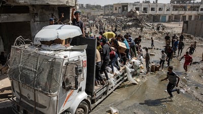 Palestinians take aid supplies from a lorry in Khan Younis, southern Gaza. EPA