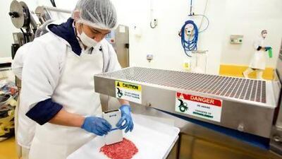 A member of staff checks the fat content of minced beef at the Spinney's meat processing facility in Jebel Ali. Christopher Pike / The National