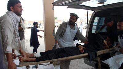 An Afghan wounded man lays on a trolley as others rush him to a hospital following blast at a voter registration centre in Khost Province on May 6, 2018. Farid Zahir / AFP