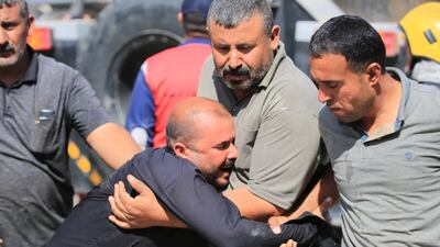 Emergency service personnel comfort a man at the scene. EPA