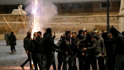 Flares explode as people gather in Piazza del Popolo square during a protest by the Forza Nuova far-right group against coronavirus restrictions, in Rome, Italy. AP