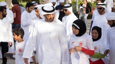 Sheikh Mohamed chats with UAE sprinter Hamda Al Hosani during a 'unified walk' at Umm Al Emarat park.
