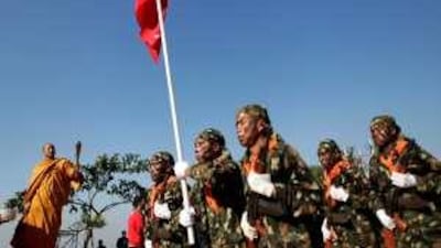 A Buddhist monk sprays holy water as Shan State Army (SSA) soldiers march through the village of Loi Tai Leng on Shan State's national day on Sunday.