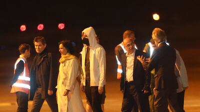 The released hostages make their way across the tarmac. EPA