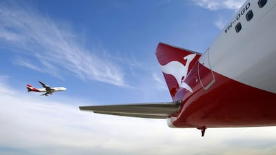A Qantas Boeing 747 flies past a 767. Qantas plans to sell older jets. Tim Wimborne /AFP
