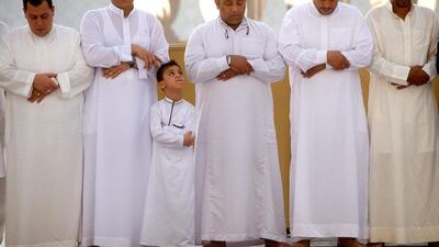 A boy looks up to a relative during Eid prayers at Sheikh Zayed Grand Mosque. Christopher Pike / The National