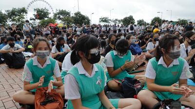 Secondary school pupils sit on the ground during a protest. AP