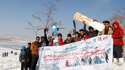 Afghan snowboard federation members and school boys posing for a group photo as they attend a practice session in Qargha lake Kabul. EPA