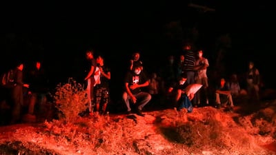 Refugees wearing facemasks gather outside the Moria camp on the island of Lesbos during a major fire there. AFP