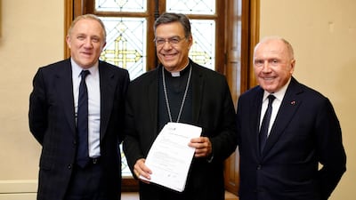 Francois-Henri Pinault, chief executive of French luxury group Kering, left, his father Francois Pinault, right, and Archbishop of Paris Michel Aupetit, centre, after signing an agreement October 1 to donate €100m towards rebuilding Notre Dame cathedral. Photo: AP