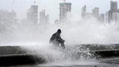 A man enjoys high tide waves on the Arabian Sea coast during monsoon rains in Mumbai. AP Photo