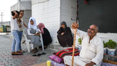 A Syrian refugee family sits in front of their home. Getty Images