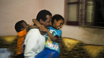 Salama plays with his children Sameh, 5, left, and Zainab, 10.