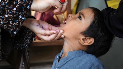 A health worker administers anti-polio vaccine drops to a child during a door-to-door vaccination campaign in Hyderabad, Pakistan. EPA