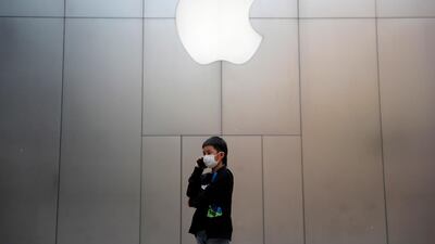 A boy wearing protective face mask uses mobile phone outside an Apple store in Beijing, China. Countries around the world are taking increased measures to stem the widespread of Covid-19 disease. EPA.