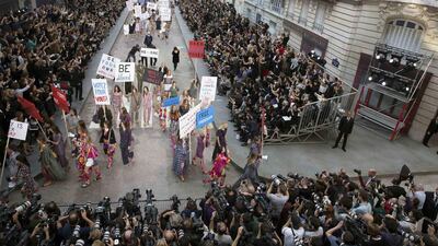 Models stage a demonstration as they present creations by German designer Karl Lagerfeld as part of his Spring/Summer 2015 women’s ready-to-wear collection for French fashion house Chanel during Paris Fashion Week September 30, 2014. Karl Lagerfeld created an immense Boulevard Chanel for his fashion show on Tuesday, even staging a street demonstration by fashionably dressed models for Spring/Summer 2015. Reuters