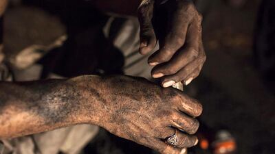 A miner covered in coal dust sits inside a mine in Choa Saidan Shah. Workers at this mine dig coal with pick axes, break it up and load it onto donkeys to be transported to the surface. Sara Farid / Reuters