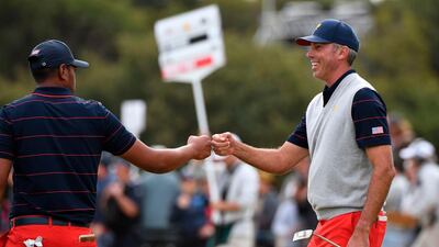 Matt Kuchar (R) and Tony Finau bump fists during the third day of the Presidents Cup. AFP