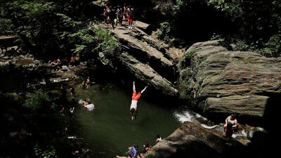 A man dives into the Devil's Pool in Wissahickon Valley Park, Thursday, July 5, 2018, in Philadelphia. (AP Photo/Matt Slocum)
