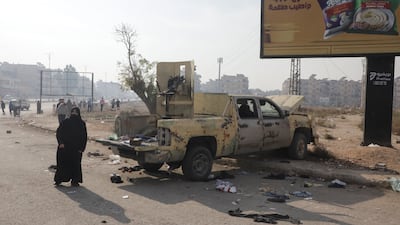 A woman walks past a damaged vehicle after rebels passed through en route to Homs on Friday. Reuters