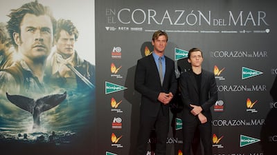 Chris Hemsworth and Tom Holland, in a black suit and T-shirt, attend the 'In the Heart of the Sea' premiere in Madrid on December 3, 2015. Getty Images