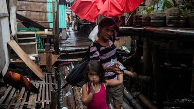 A woman and a child evacuate from a coastal community ahead of Typhoon Vamco, in Sucat, Muntinlupa, Metro Manila, Philippines. Reuters