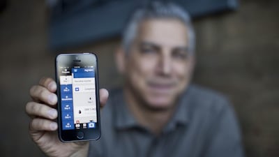 Ali Dabaja, the founder and chief executive of Hajjnet displays the application on his iPhone. Razan Alzayani / The National