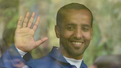 Hazza Al Mansouri waves to crowds as they leave for the launch pad. EPA