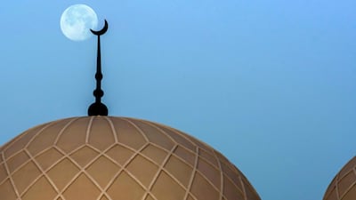 The moon rises in the sky behind the Saeed Mohammed Al Khalili Mosque at Khalifa City, Abu Dhabi. Victor Besa / The National