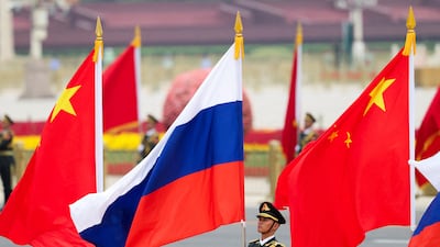 PLA honour guards hold Chinese and Russian flags. Reuters